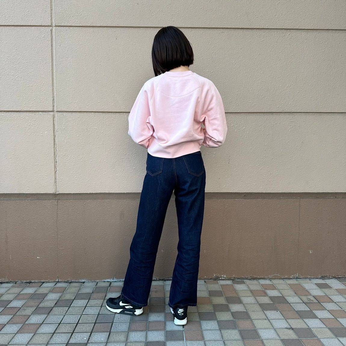 スウェットシャツを着た女性スタッフの背面