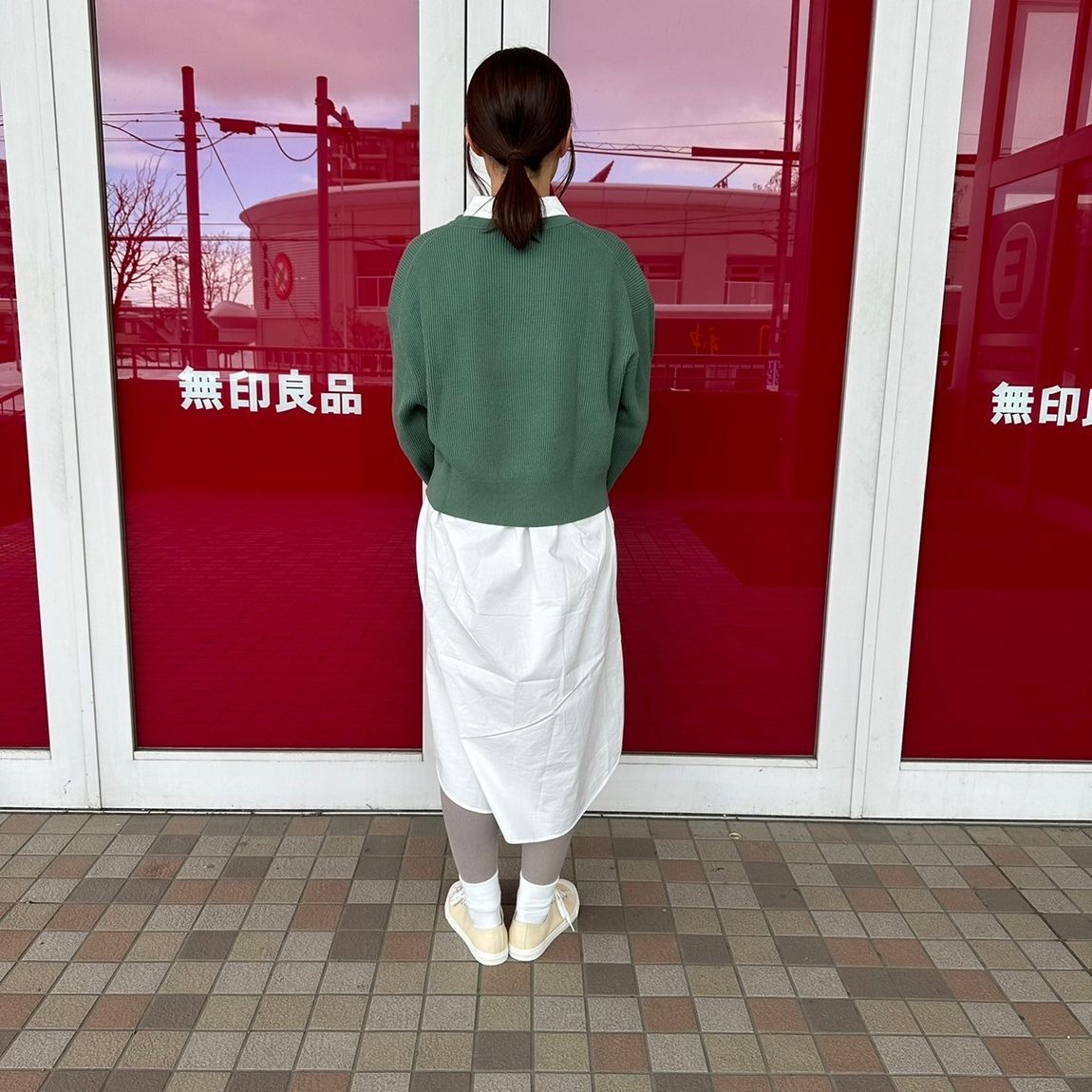 クルーネックセーターを着た女性スタッフの背面