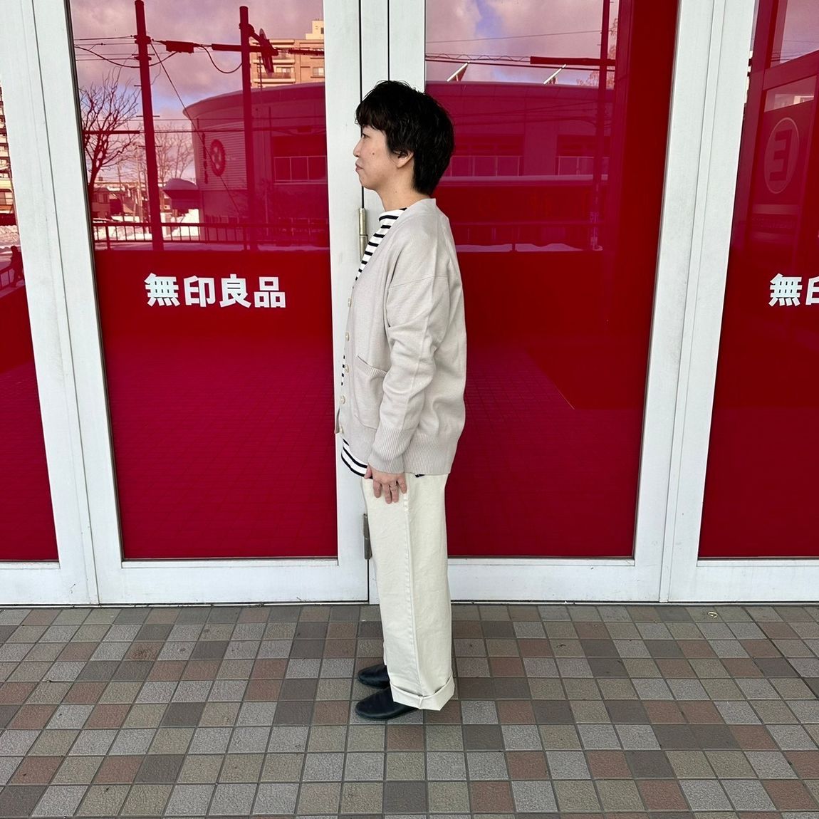 Vネックカーディガンを着た女性スタッフの側面
