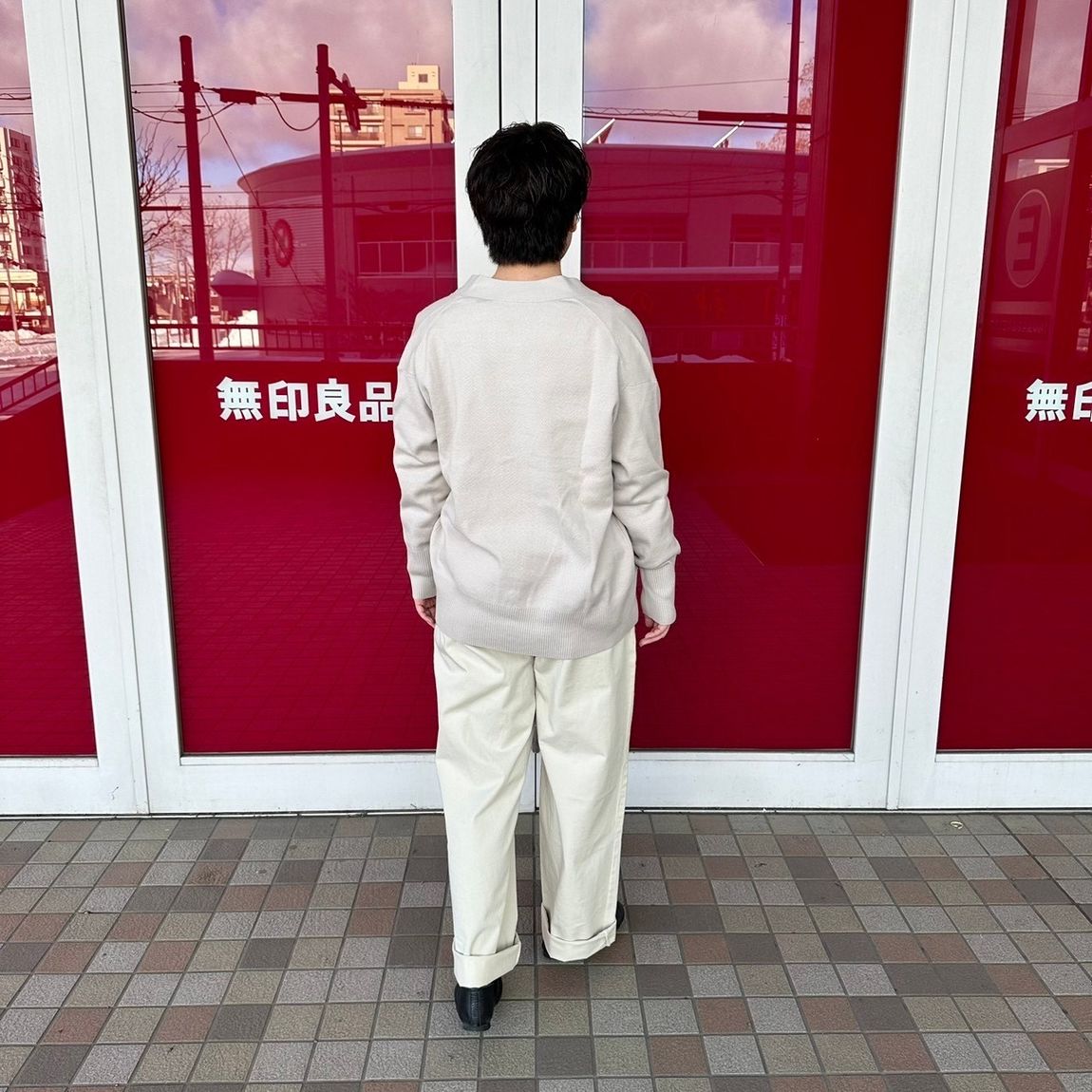 Vネックカーディガンを着た女性スタッフの背面