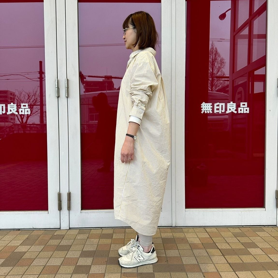 レギュラーカラーワンピースを着た女性スタッフの側面