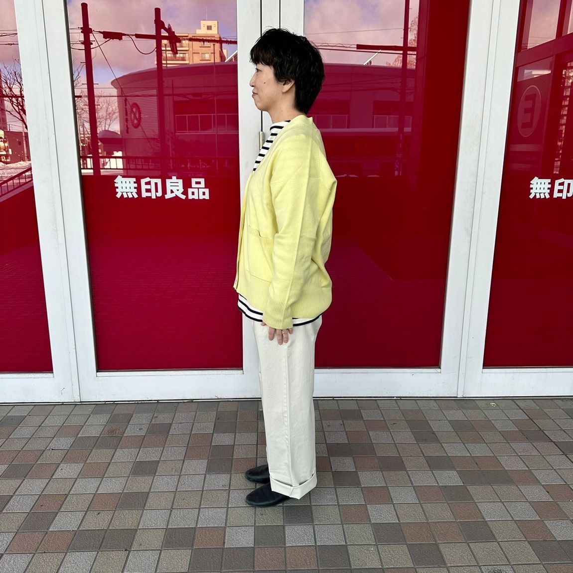 Vネックカーディガンを着た女性スタッフの側面