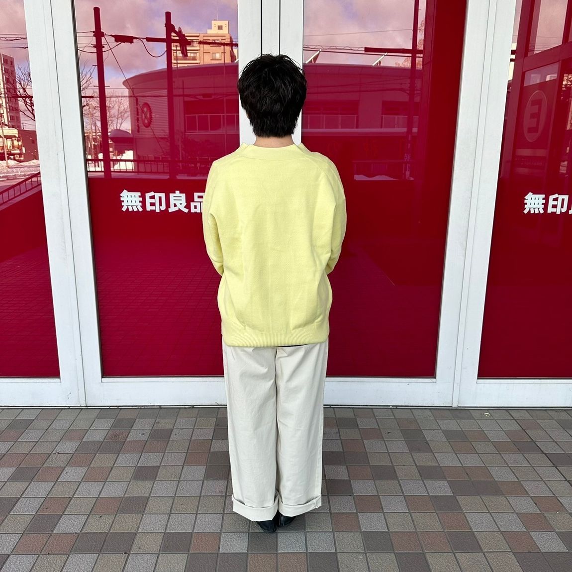 Vネックカーディガンを着た女性スタッフの背面