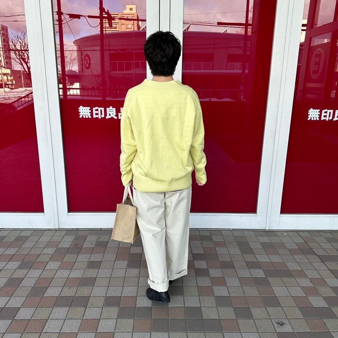 Vネックカーディガンを着た女性スタッフの背面