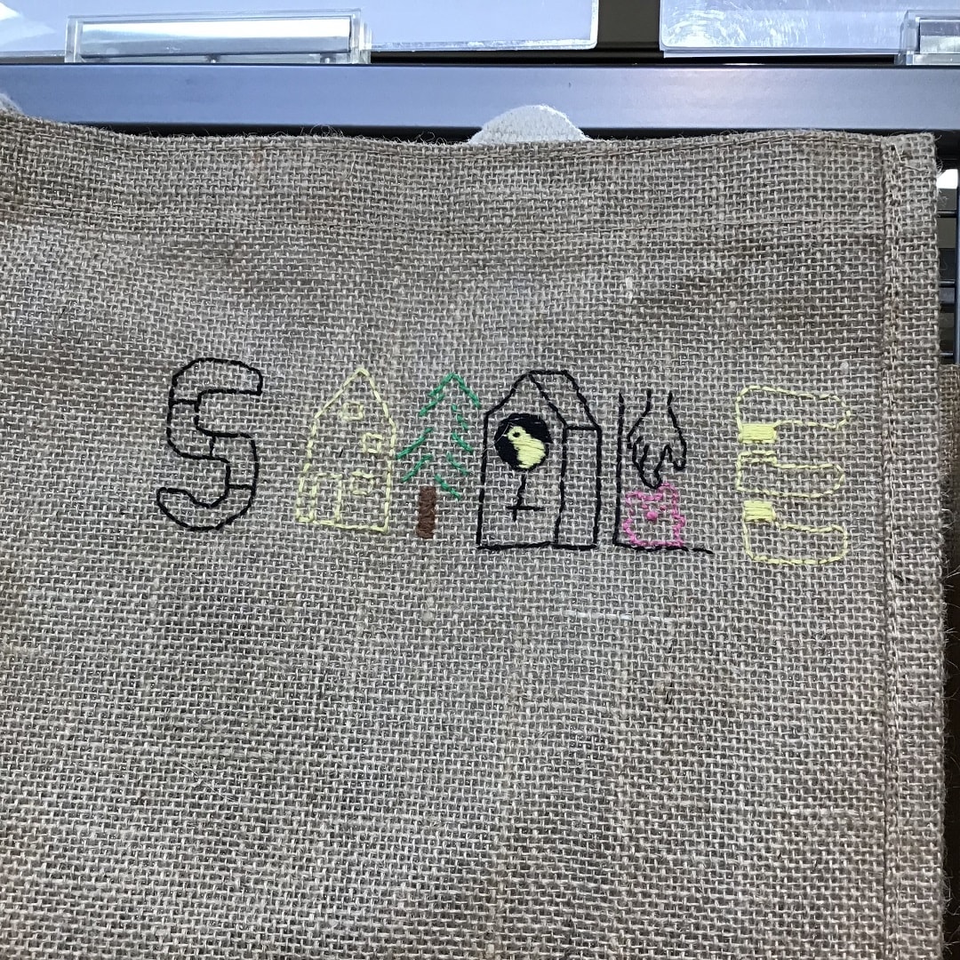 SMILEの文字を刺繍したジュートマイバッグの写真