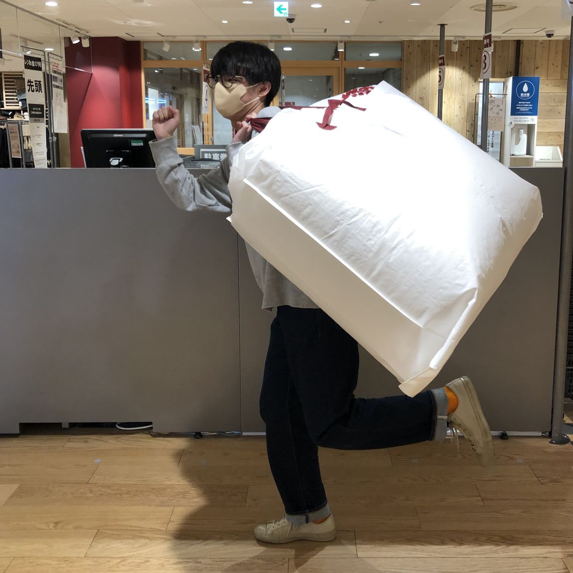 体にフィットするソファをショッピングバッグに入れて持ち帰っている様子