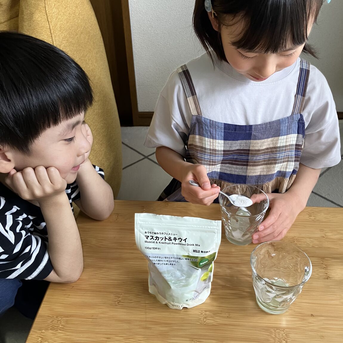子供が粉を入れている写真