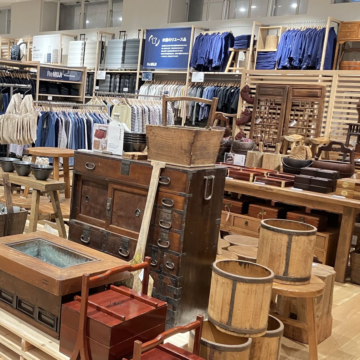 ReMUJI売場の壁面に並ぶ食器と古家具の展示風景