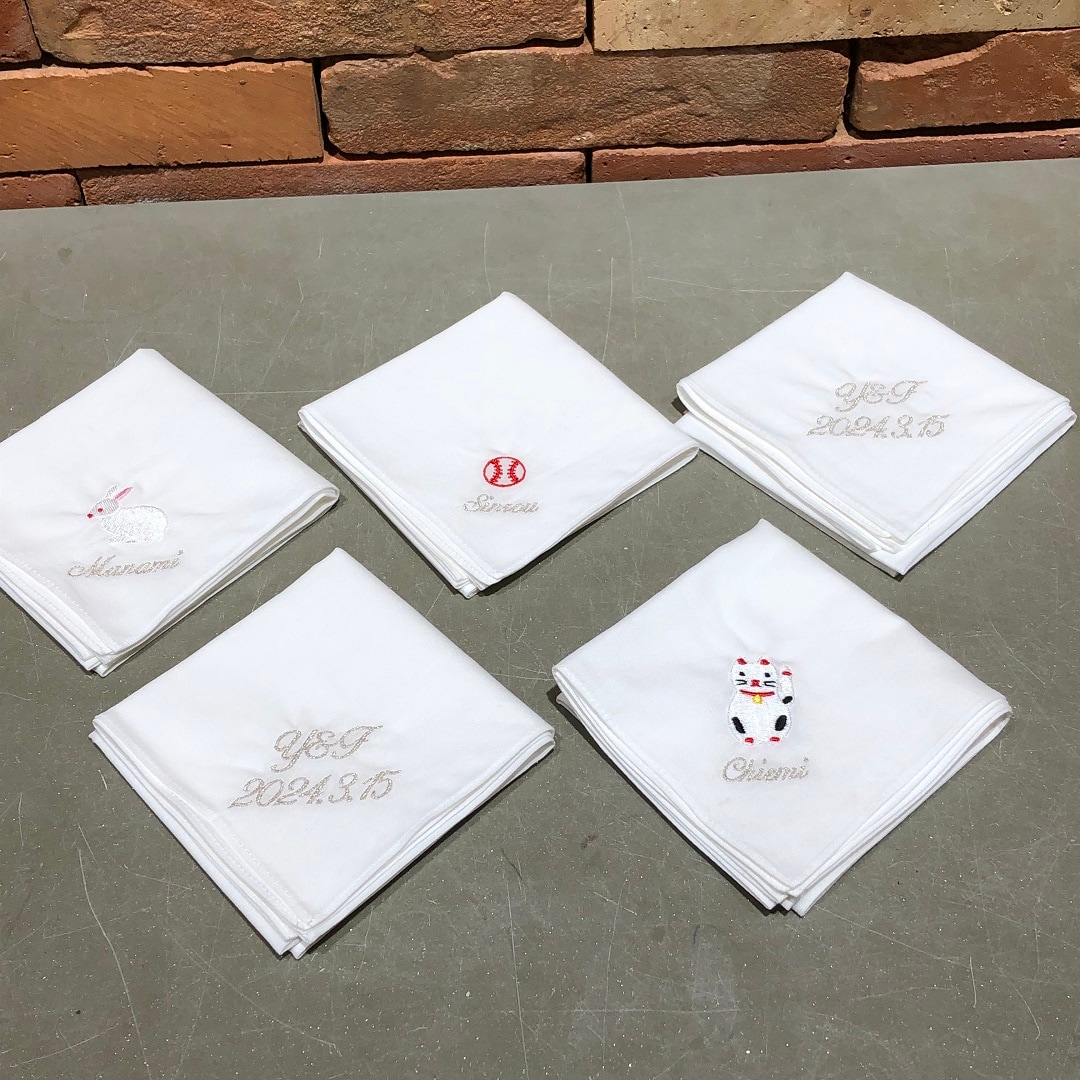 文字とマークの刺繡の入ったハンカチ
