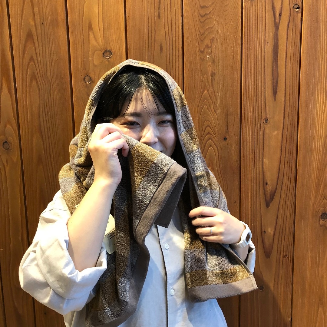 黄色のタオルで頭をふく女性