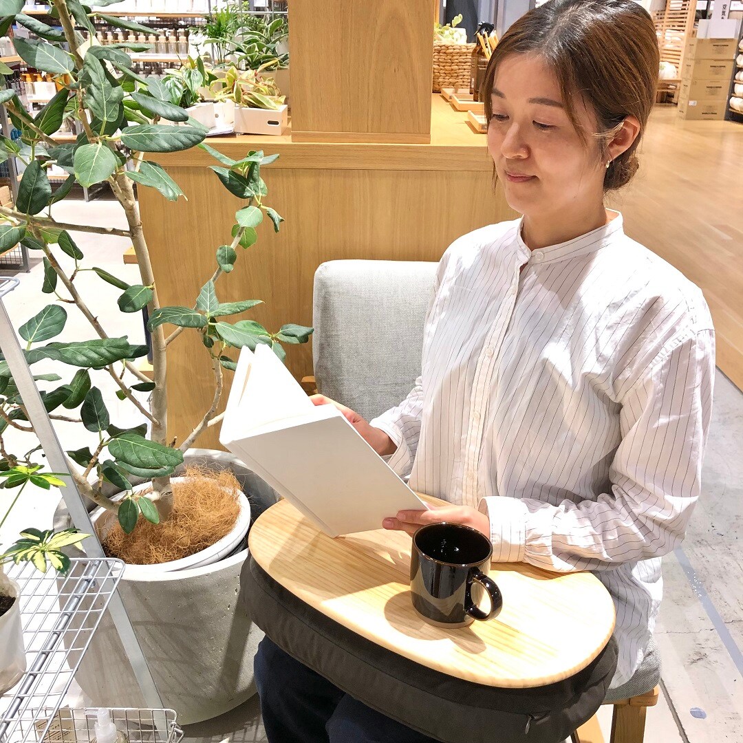 ひざの上でつかえるテーブルクッションと人