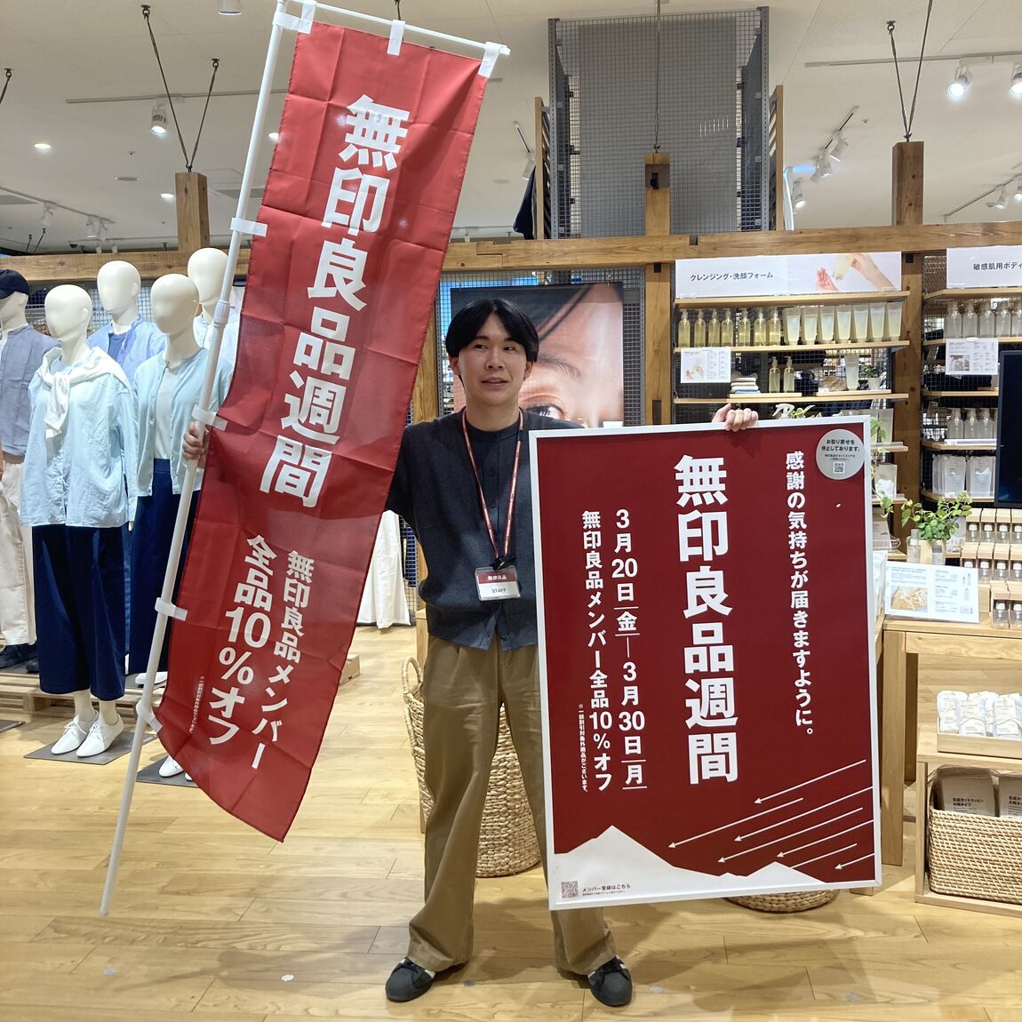 男性が無印良品週間ののぼりを持っています
