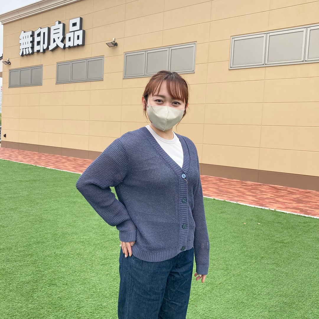 カーディガンをはおった女性スタッフ