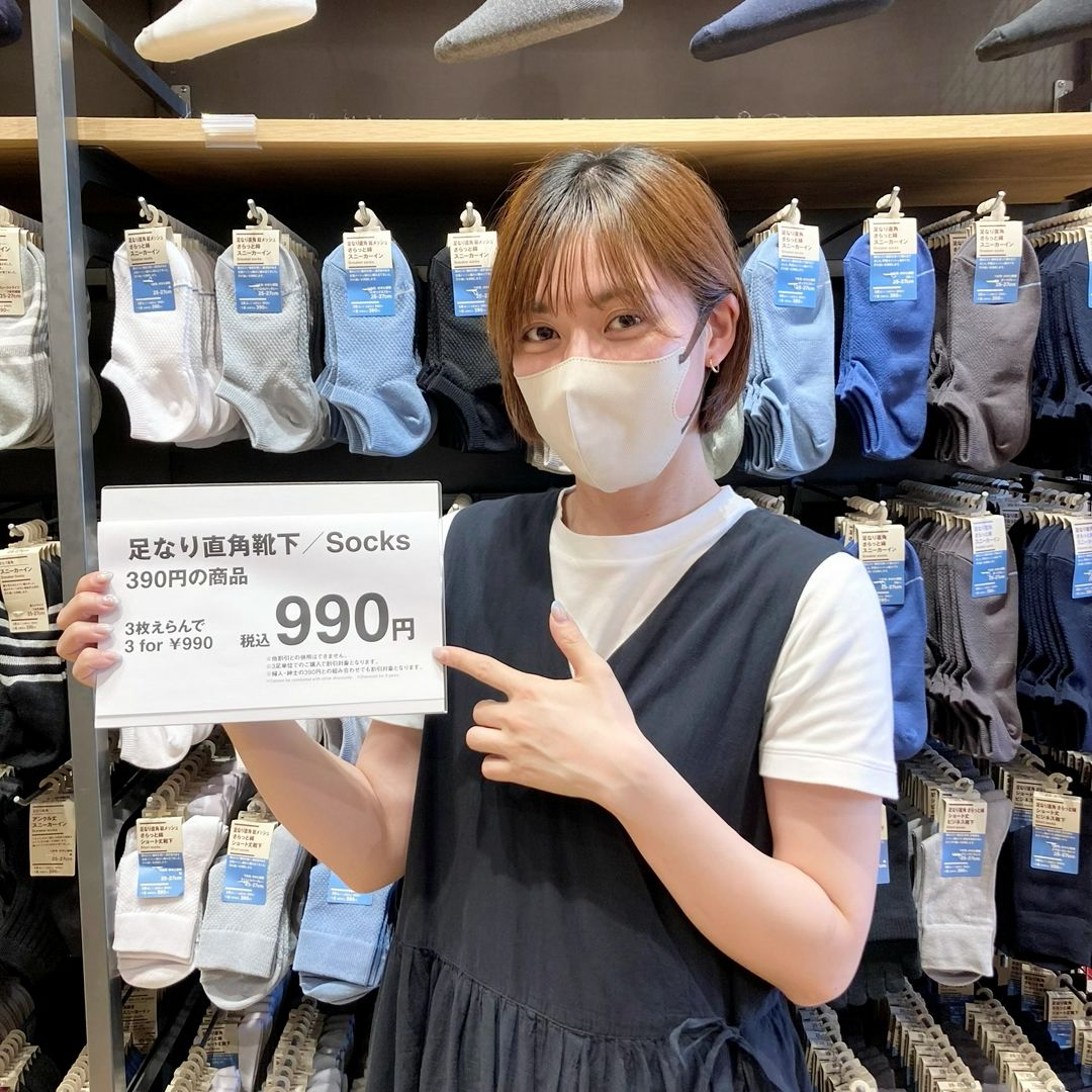 靴下の商品POPを持っている女性の写真