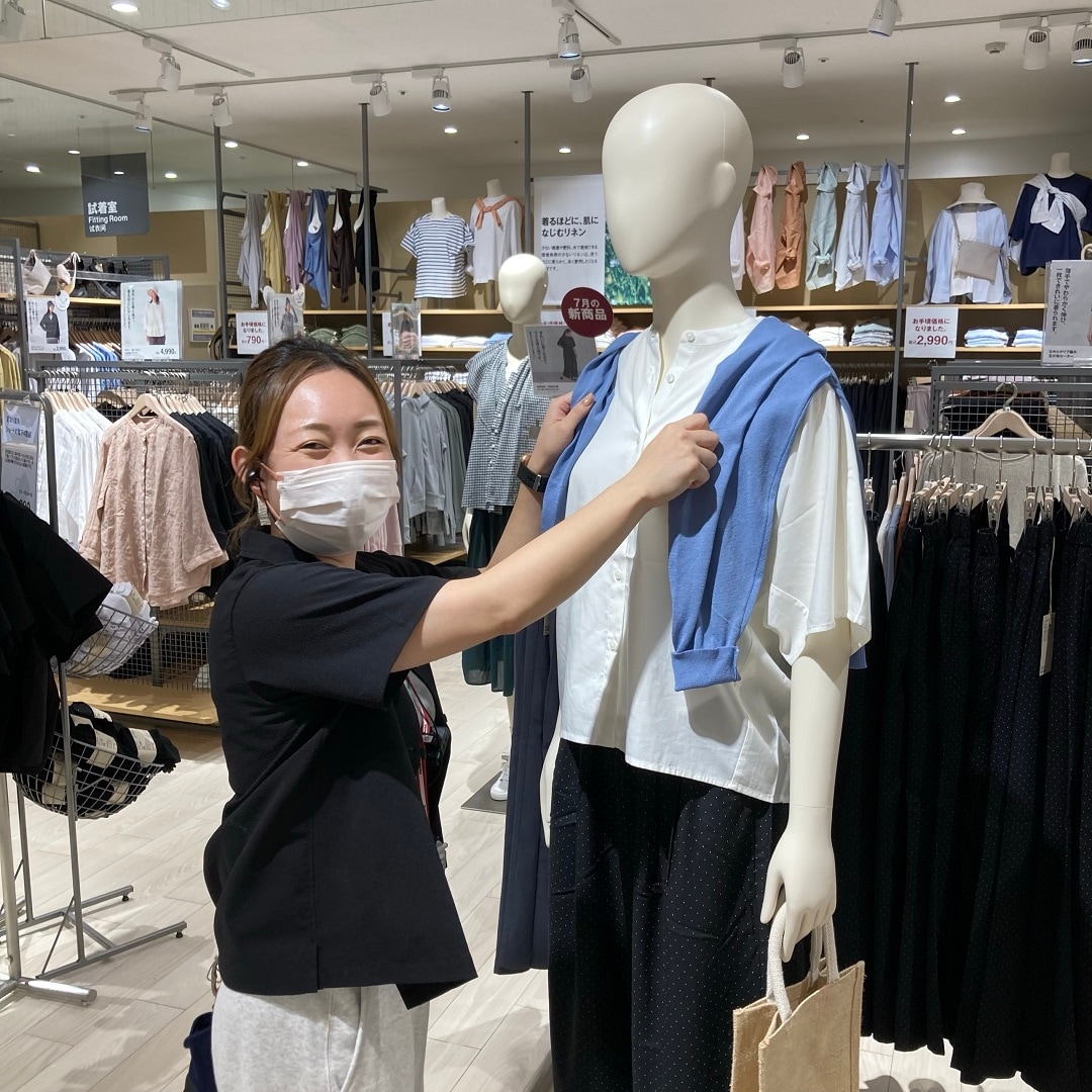マネキンに服を着せているスタッフ