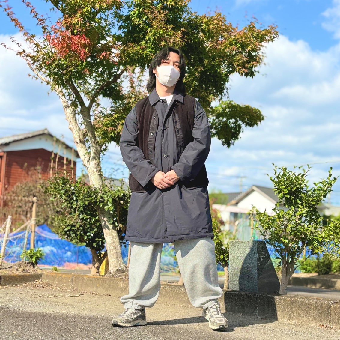 ステンカラーコートの上にフリースベストを合わせたコーディネートのスタッフの写真です。