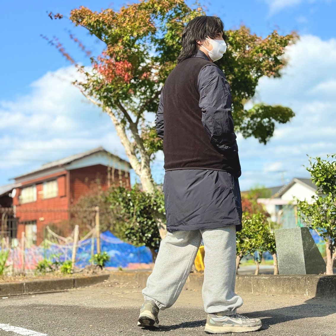 ステンカラーコートの上にフリースベストを合わせたコーディネートのスタッフの写真です。