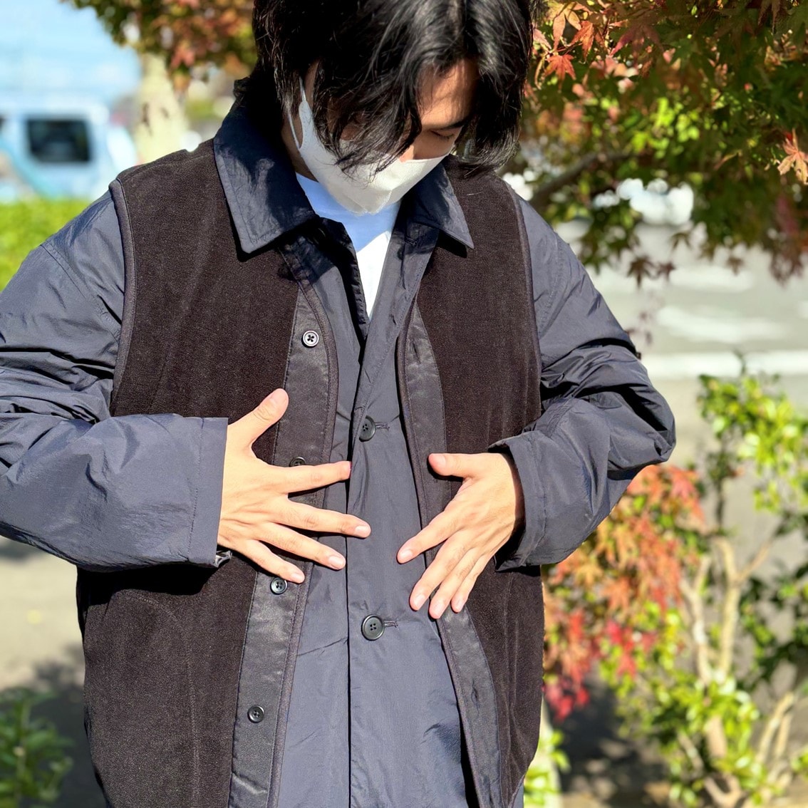 ステンカラーコートの上にフリースベストを合わせたコーディネートのスタッフの写真です。