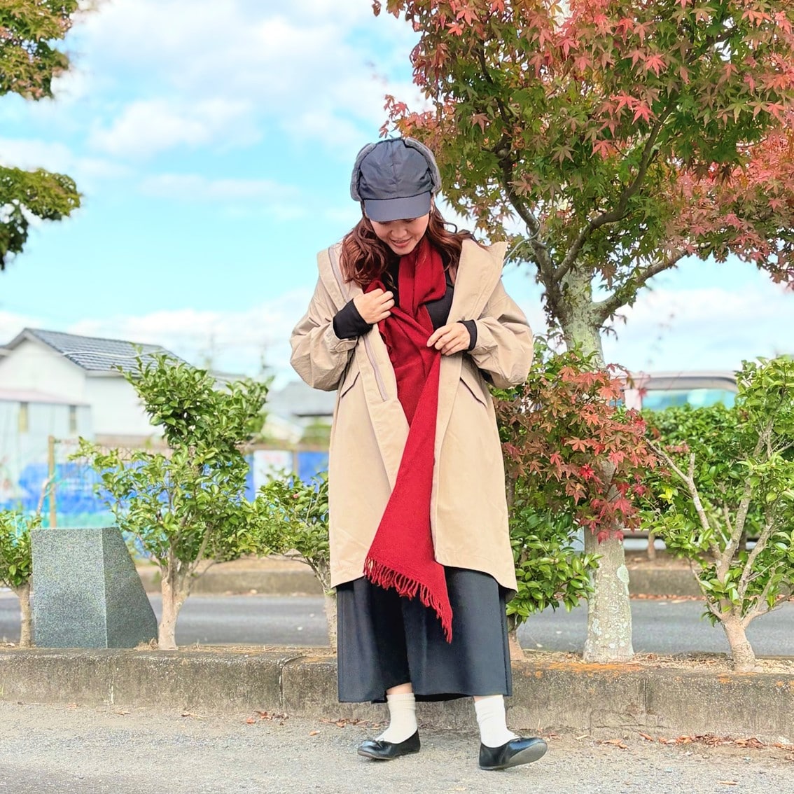 フライトキャップと赤いマフラーでカジュアルにコーディネートしたスタッフの写真です。