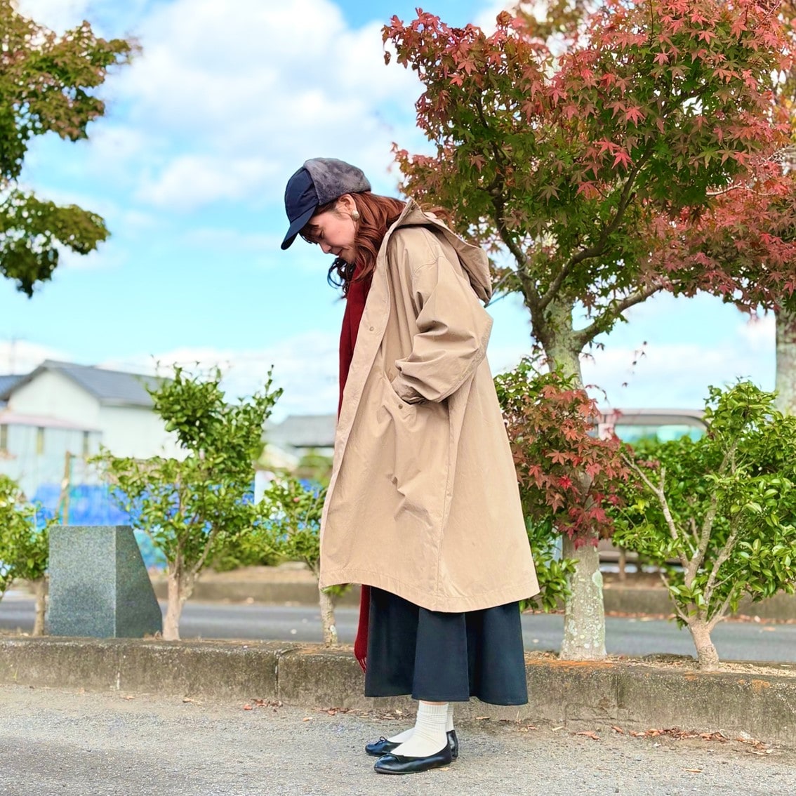 フライトキャップと赤いマフラーでカジュアルにコーディネートしたスタッフの写真です。