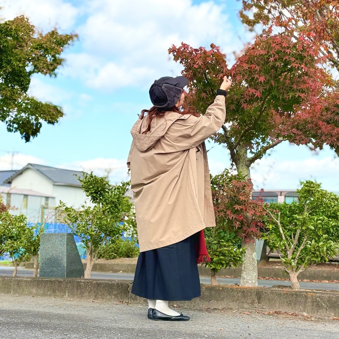 フライトキャップと赤いマフラーでカジュアルにコーディネートしたスタッフの写真です。