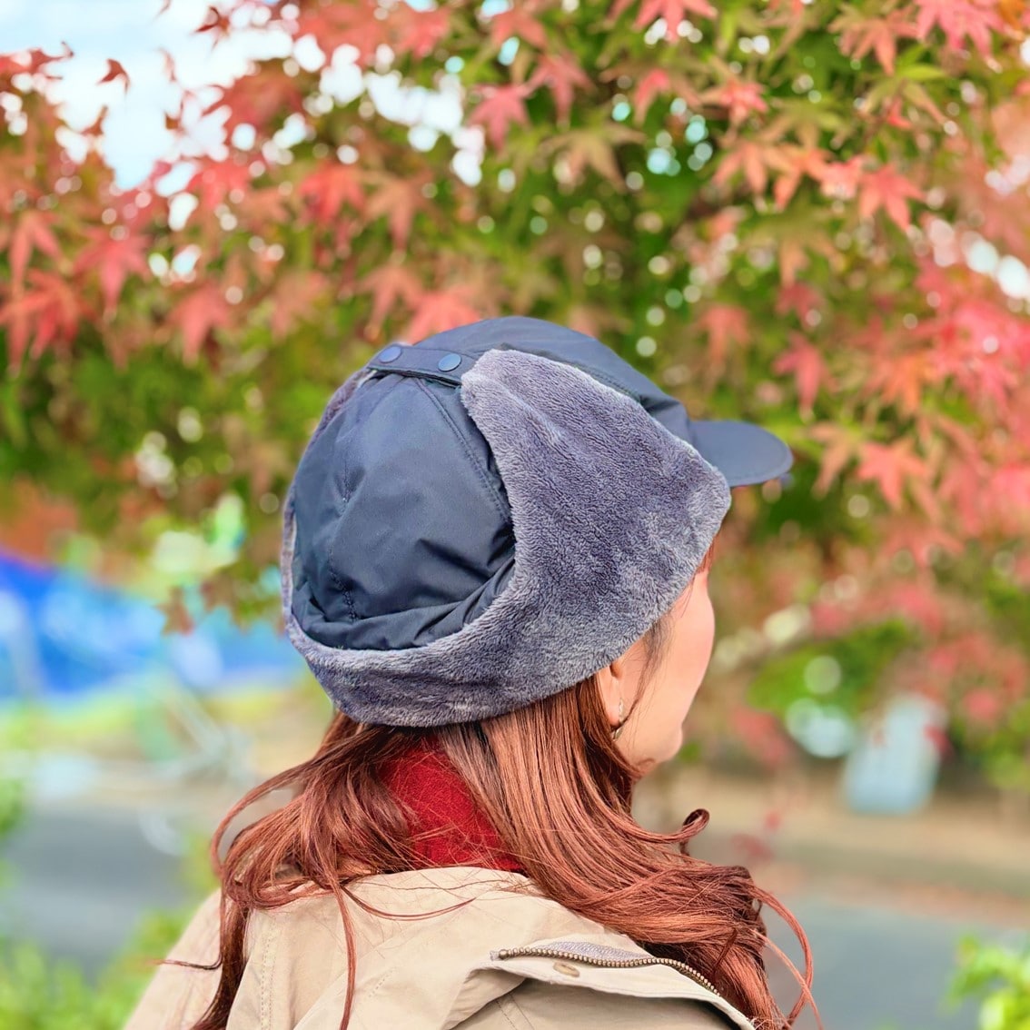 フライトキャップと赤いマフラーでカジュアルにコーディネートしたスタッフの写真です。