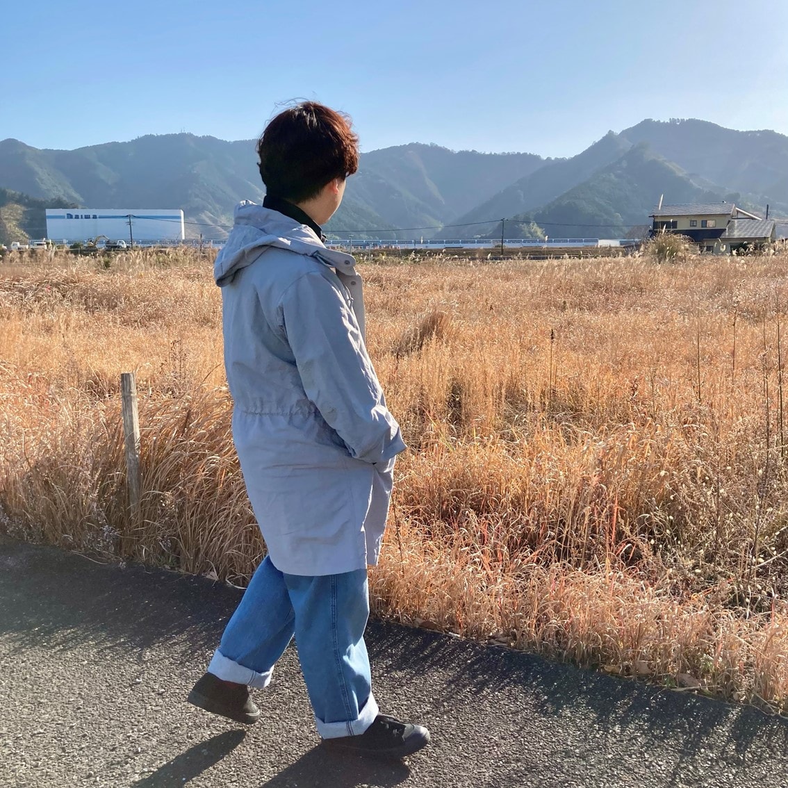 ハーフジップスウェットシャツに撥水フード付きコートを合わせたコーディネートのスタッフの写真です。