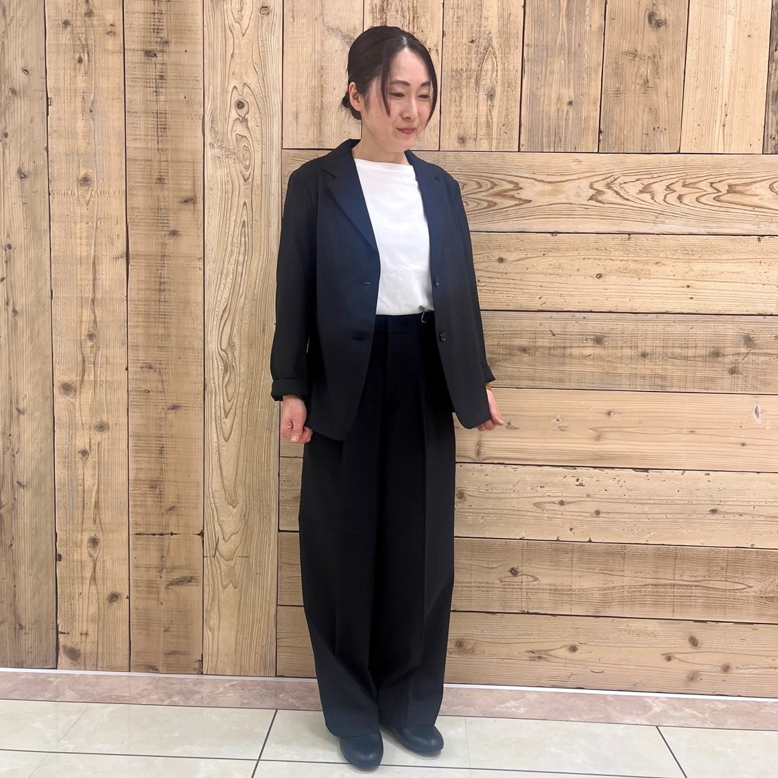 撥水ストレッチのテーラードジャケットにタックストレートパンツを合わせたコーディネートのスタッフの写真です。