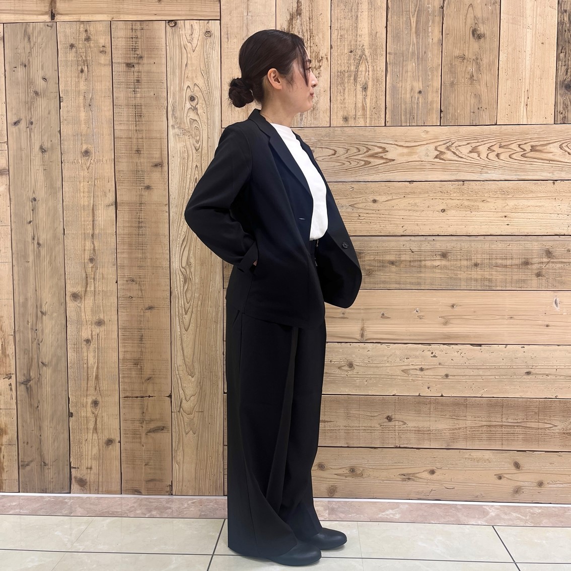 撥水ストレッチのテーラードジャケットにタックストレートパンツを合わせたコーディネートのスタッフの写真です。