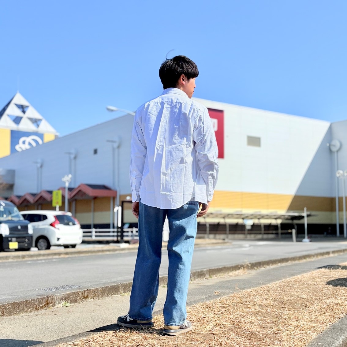 洗いざらしオックスボタンダウン長袖シャツにデニムパンツを合わせたコーディネートのスタッフの写真です。