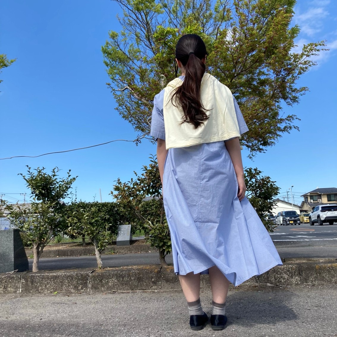 涼感半袖シャツワンピースに強撚天竺編み長袖Tシャツを肩にかけるコーディネートにしたスタッフの写真です。