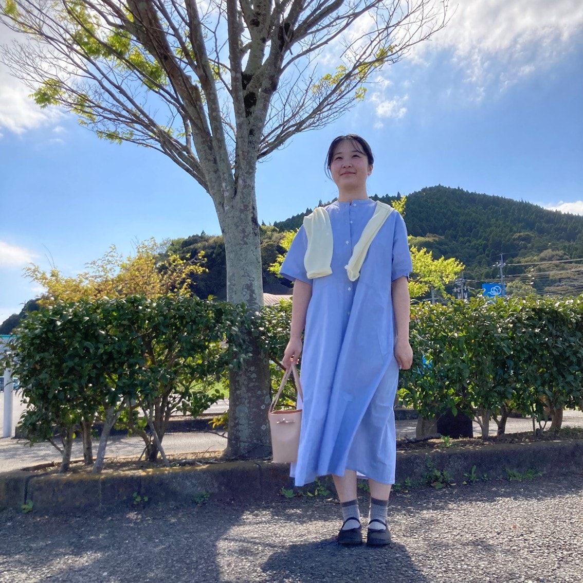 涼感半袖シャツワンピースに強撚天竺編み長袖Tシャツを肩にかけるコーディネートにしたスタッフの写真です。