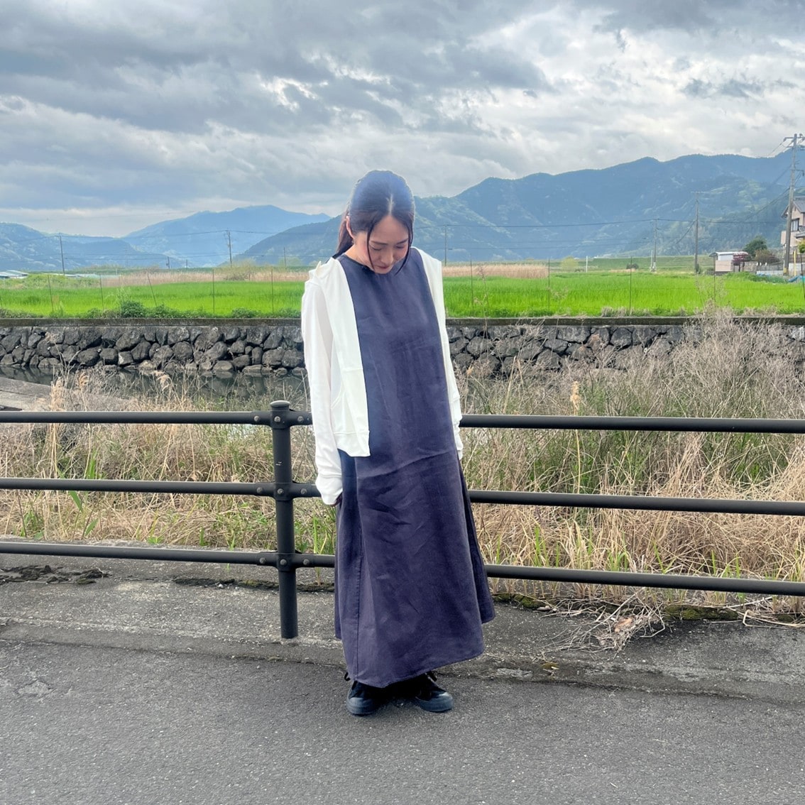 リネンのスリーブレスワンピースにフルジップパーカを合わせたコーディネートのスタッフの写真です。