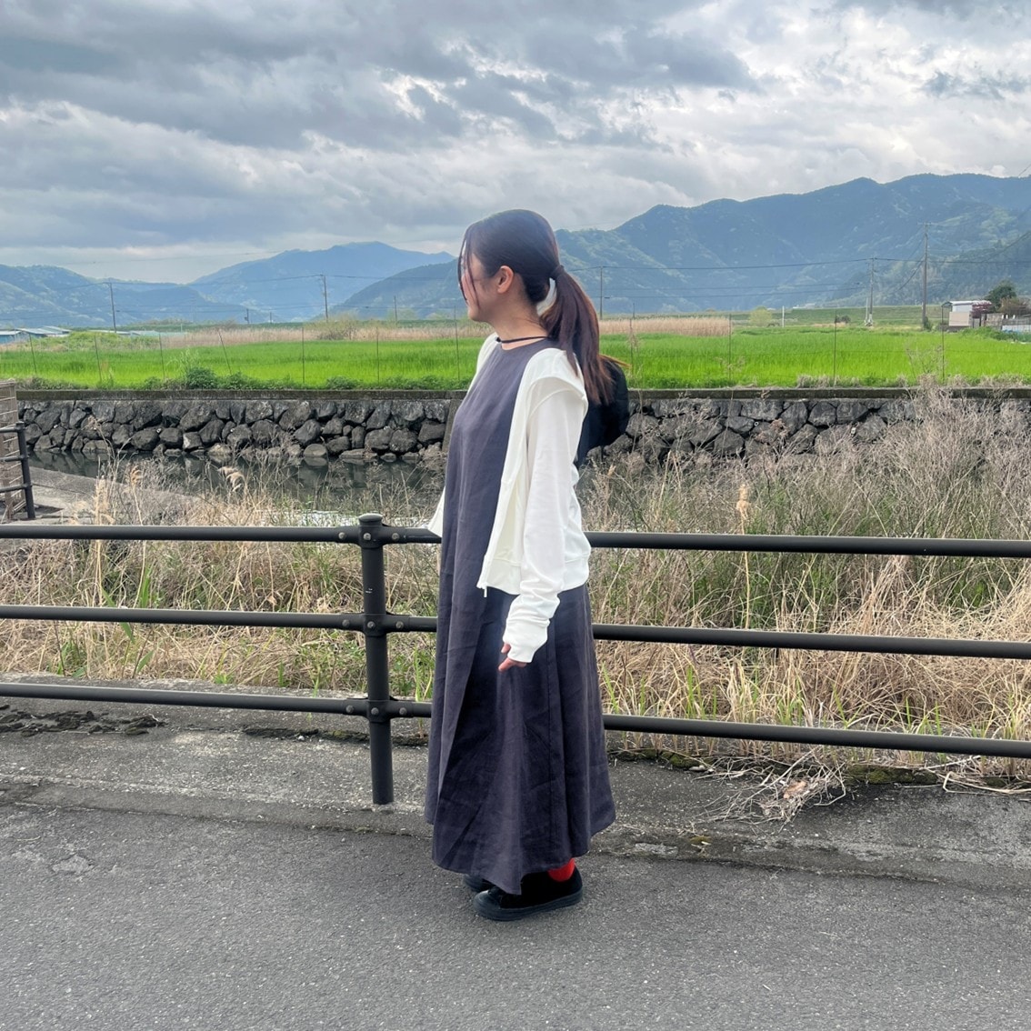 リネンのスリーブレスワンピースにフルジップパーカを合わせたコーディネートのスタッフの写真です。