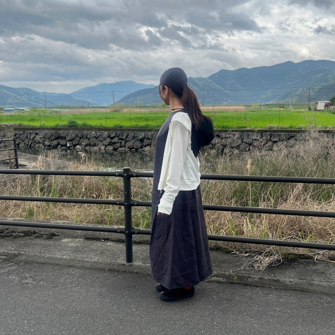 リネンのスリーブレスワンピースにフルジップパーカを合わせたコーディネートのスタッフの写真です。