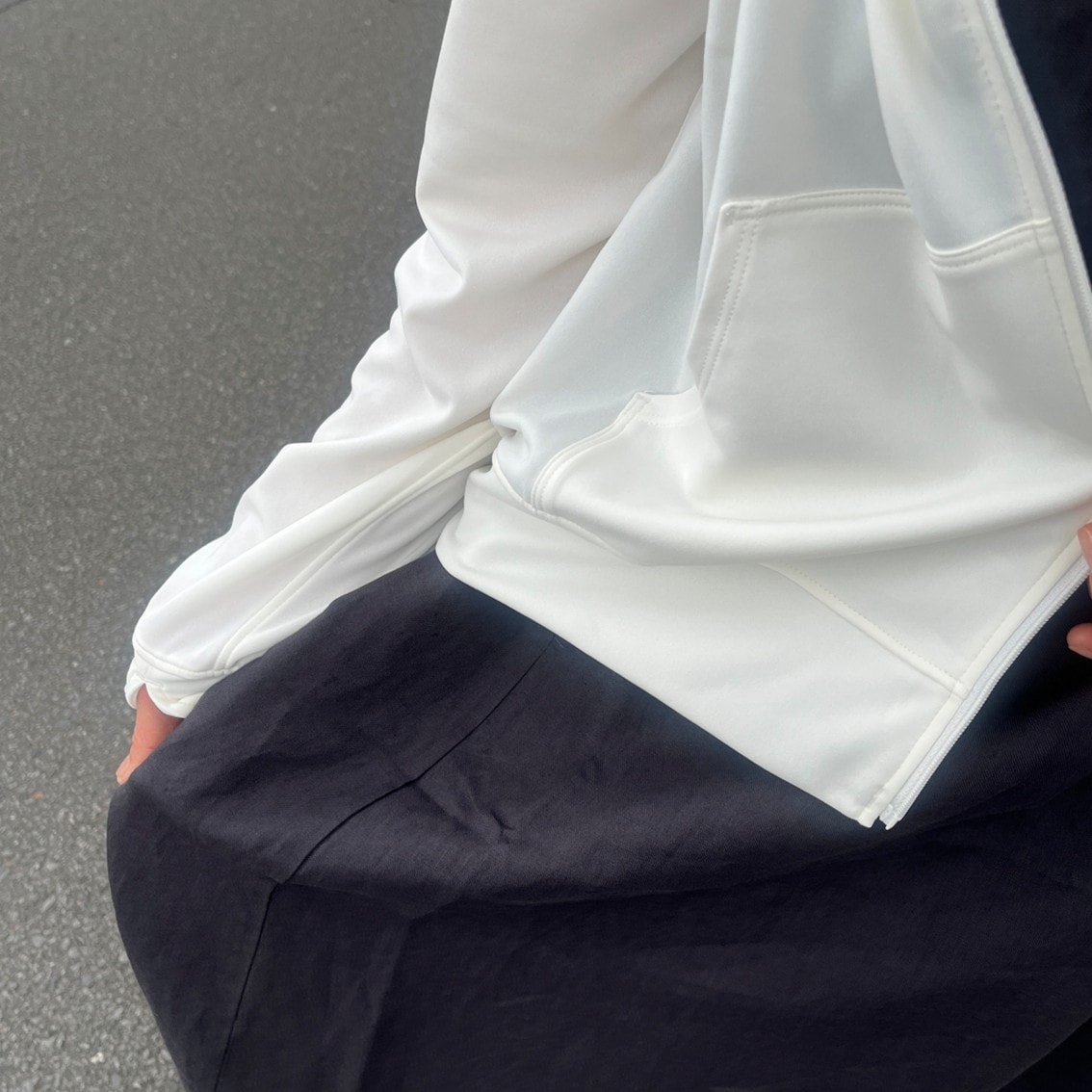 リネンのスリーブレスワンピースにフルジップパーカを合わせたコーディネートのスタッフの写真です。