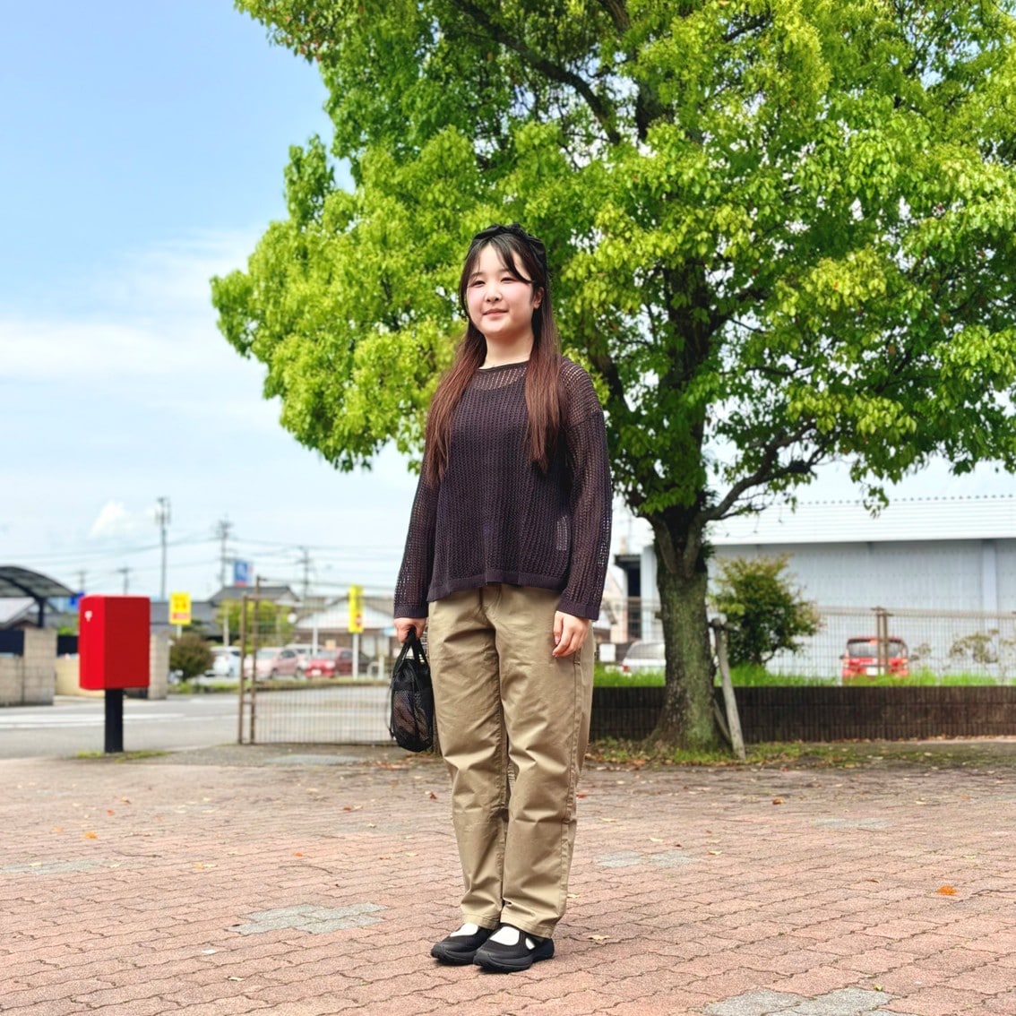 リネン混透かし編みワイドセーターやメッシュの小物を使った透け感のあるコーディネートのスタッフの写真です。