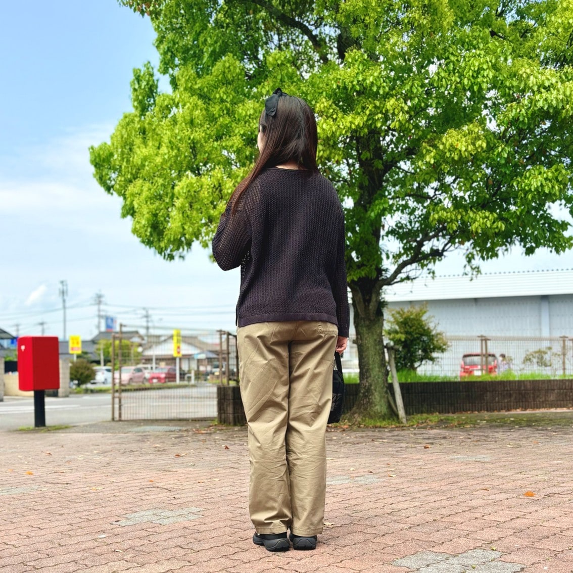 リネン混透かし編みワイドセーターやメッシュの小物を使った透け感のあるコーディネートのスタッフの写真です。