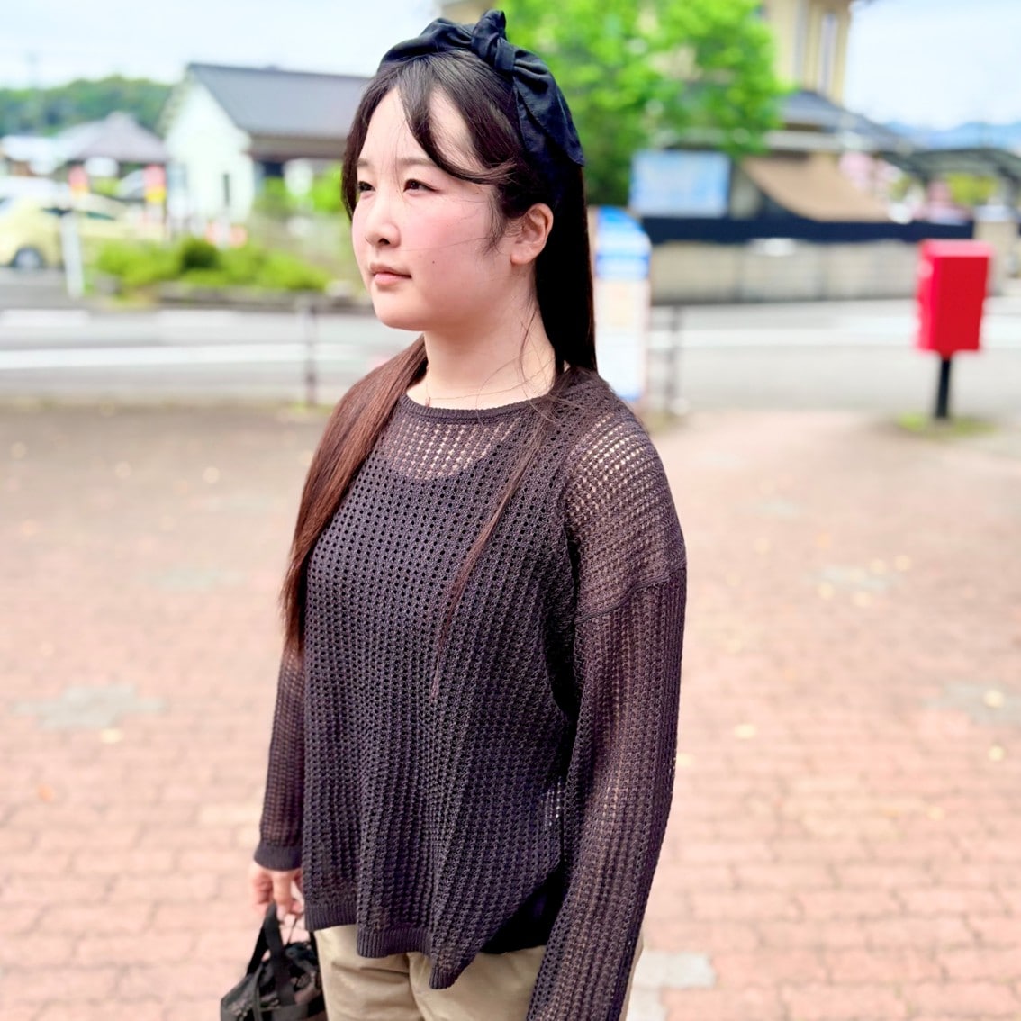 リネン混透かし編みワイドセーターやメッシュの小物を使った透け感のあるコーディネートのスタッフの写真です。