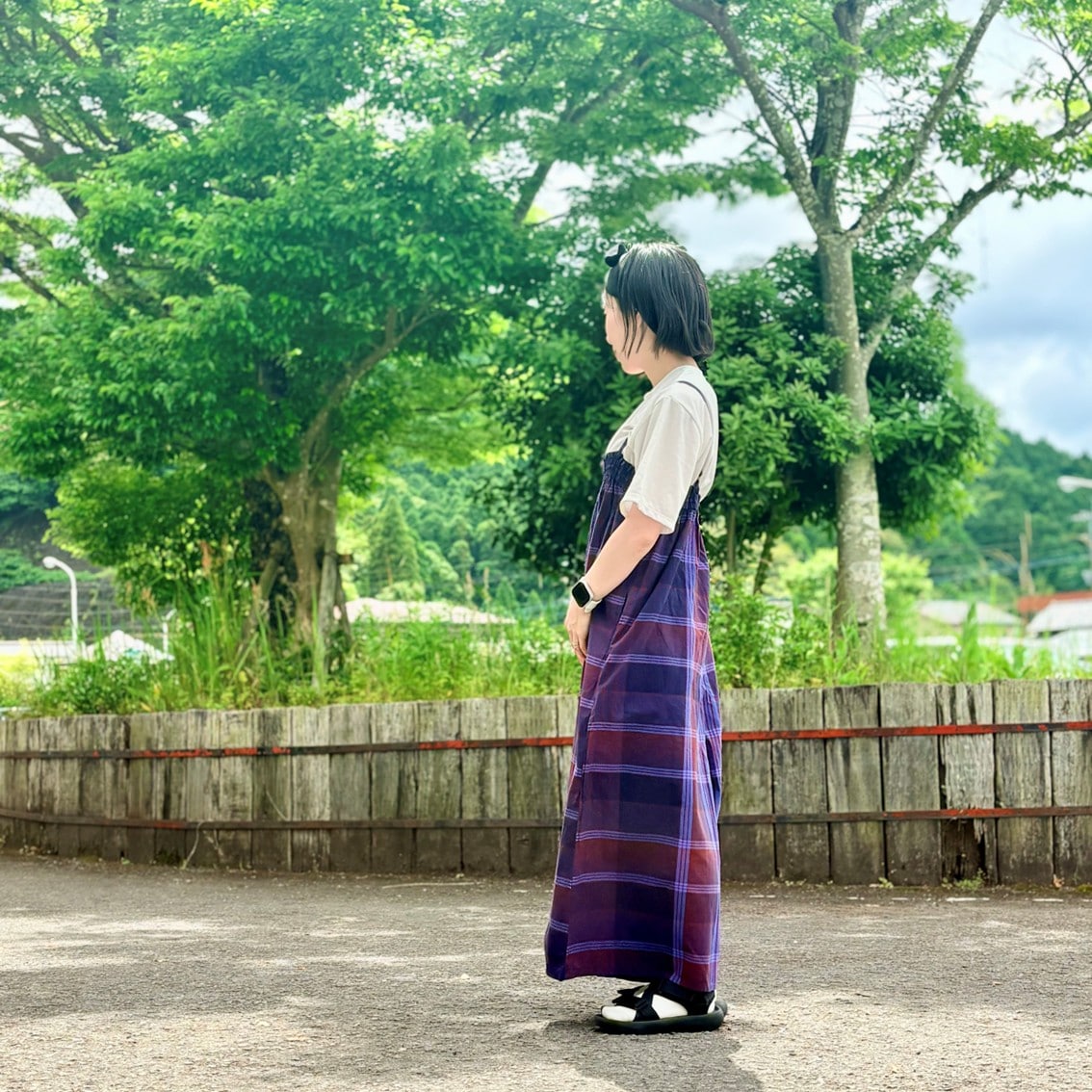 マドラスチェックサロペットを着用したスタッフの写真です。