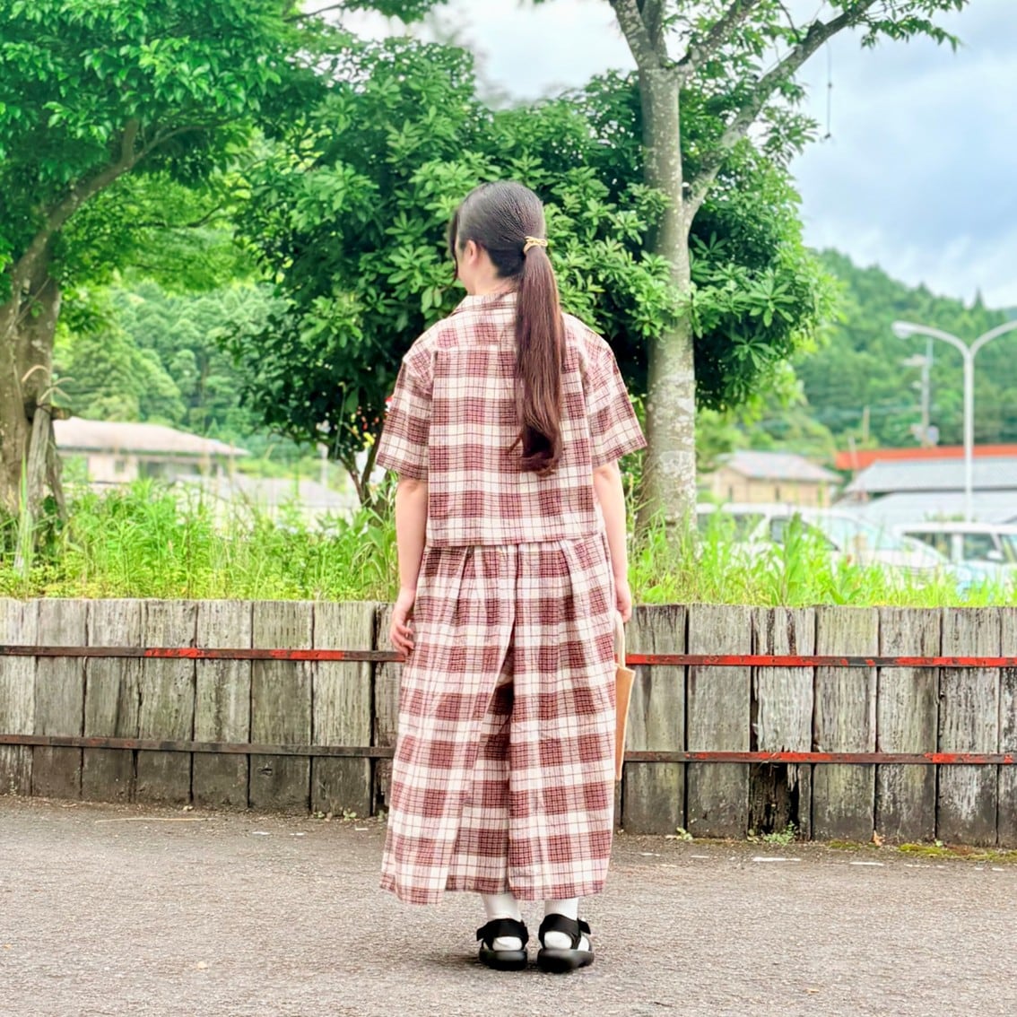 マドラスチェックの半袖ブラウスとスカートパンツのセットアップにしたスタッフの写真です。