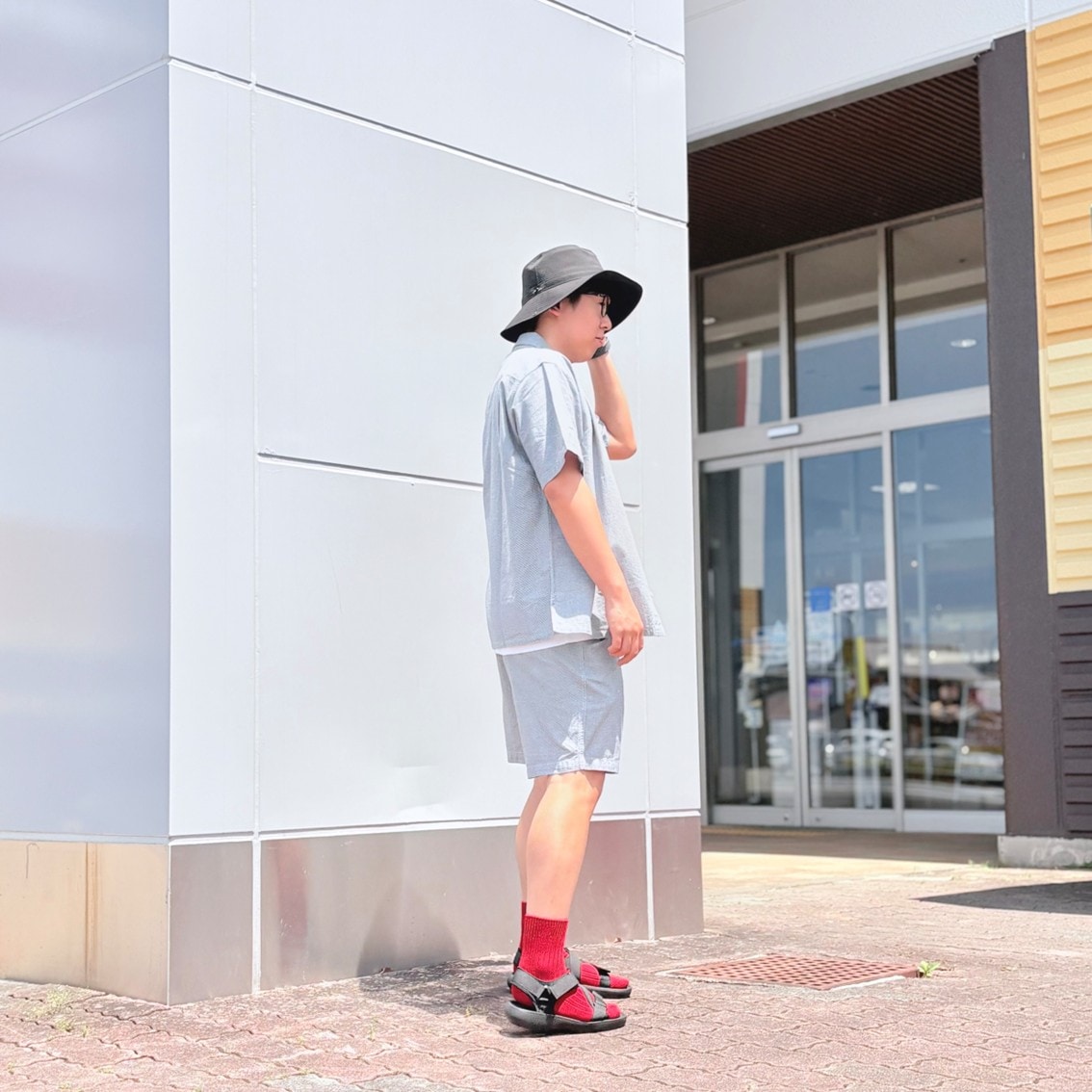 マドラスチェックの半袖シャツとハーフパンツのセットアップにしたスタッフの写真です。