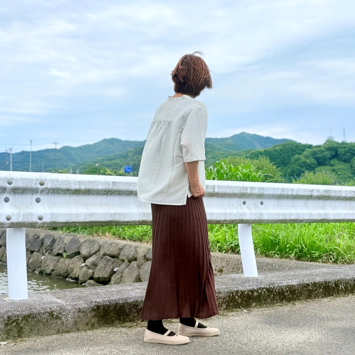 なめらか5分袖ブラウスになめらかニットフレアスカートを合わせたコーディネートのスタッフの写真です。