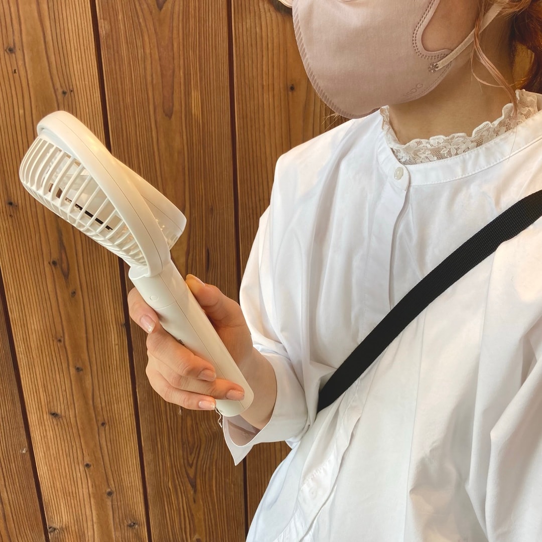 人がハンディファンを使用している画像