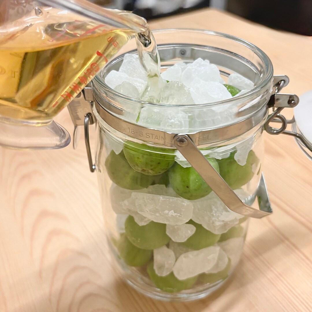 「果実酒用ビン」にリンゴ酢をまわしかけているイメージ画像