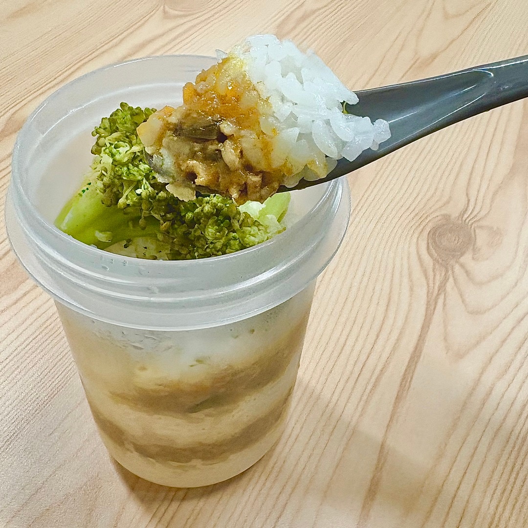 「トッピングカップ付き ランチカプセル」にカレーを入れているイメージ画像