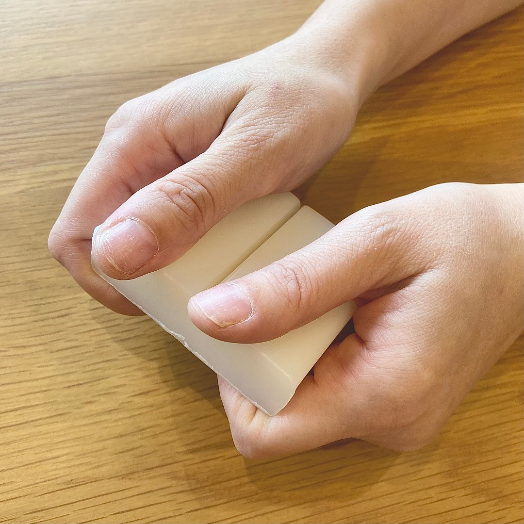 「敏感肌用石けん　全身用」を手でわる様子