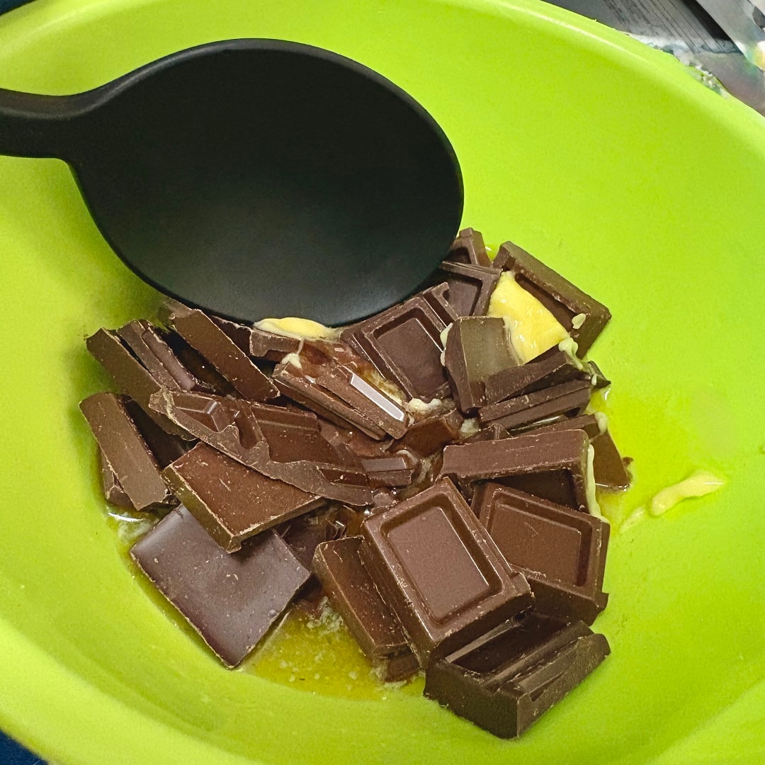 耐熱容器に砕いたチョコレートとバターを入れているイメージ画像
