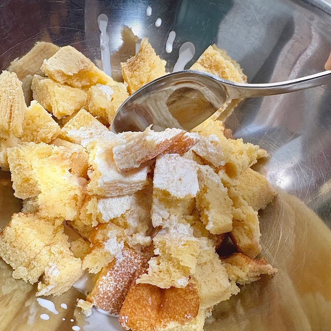 手でちぎったバウムに生クリームを加えているイメージ画像