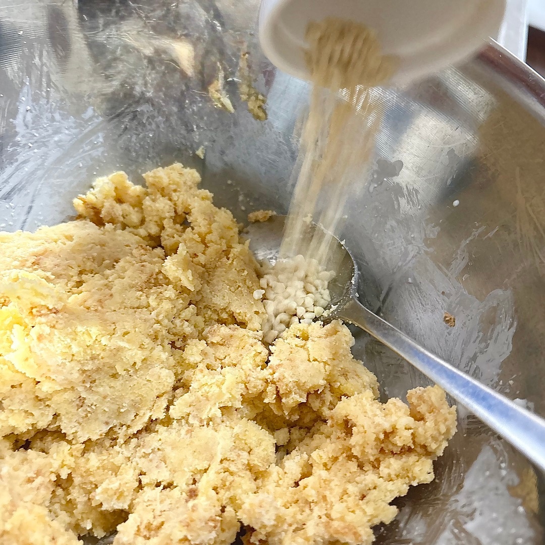 生地の中にアーモンドダイスを加えているイメージ画像